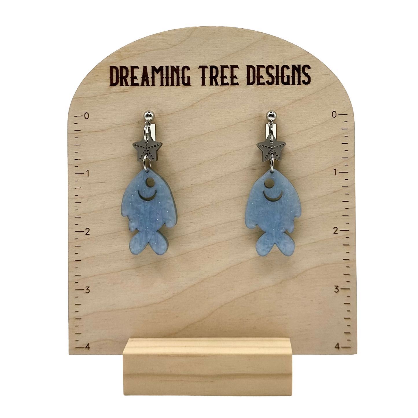 a pair of earrings with a fish design on them