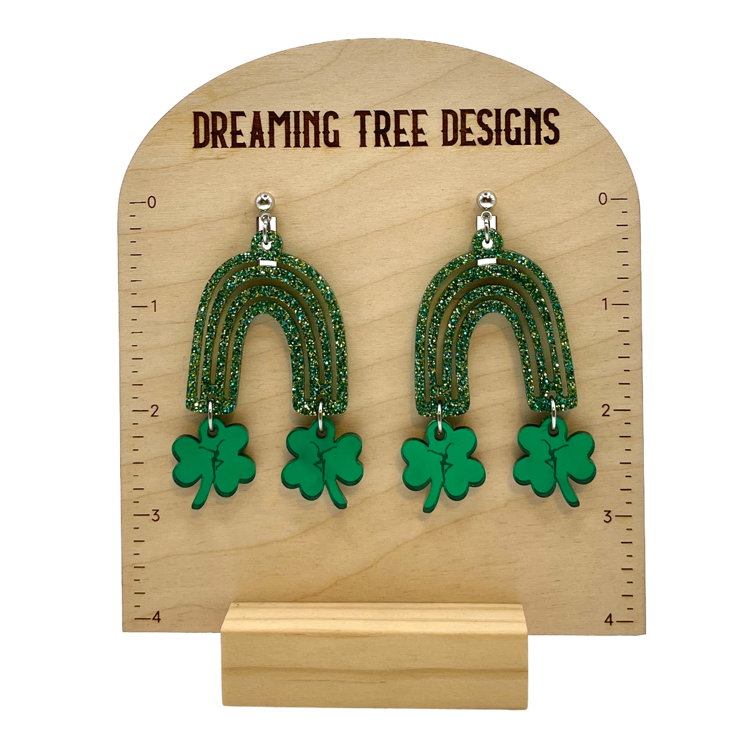 a pair of green beaded earrings on a wooden stand