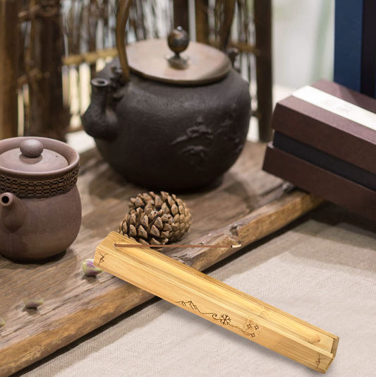 a wooden table topped with a tea pot next to a pine cone