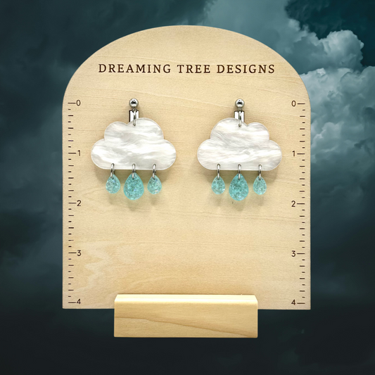 a pair of earrings is shown on a ruler