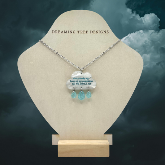 a necklace on a mannequin with clouds in the background