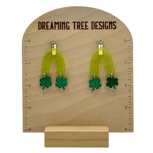 a pair of green earrings on a wooden stand