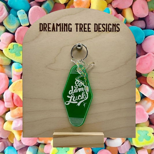 a wooden keychain with a green bottle on it