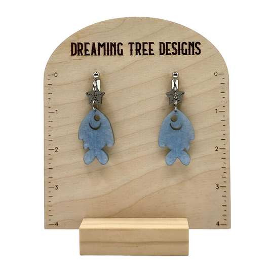 a pair of earrings with a fish design on them