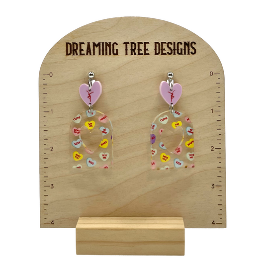 a pair of earrings that are on a stand